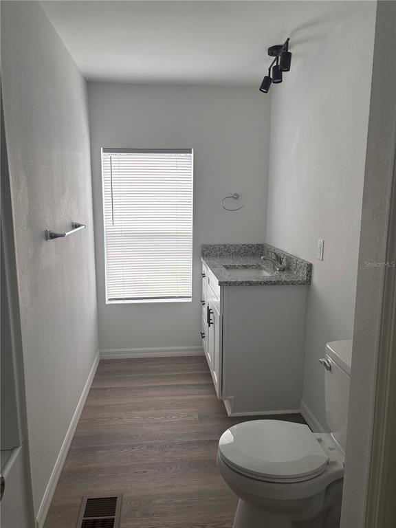 3923 Ward Road Lakeland, FL 33810 - Photo 22 of 25 a bathroom with a granite countertop toilet a sink and a window