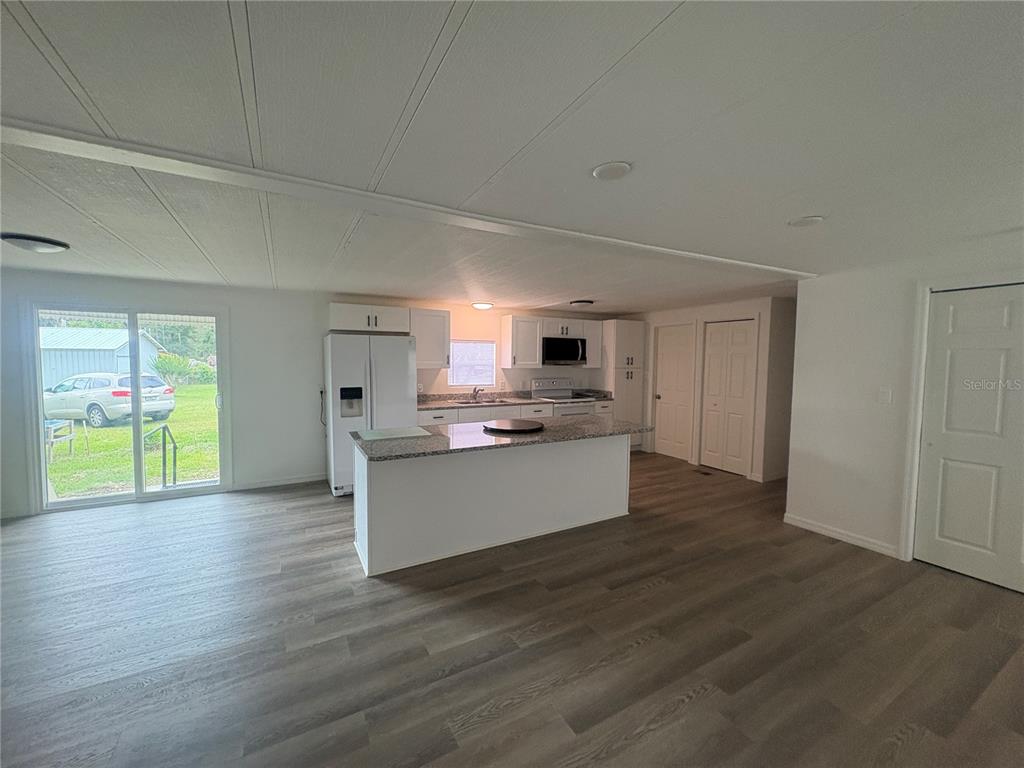 3923 Ward Road Lakeland, FL 33810 - Photo 10 of 25 a large kitchen with kitchen island a sink wooden floor and a refrigerator
