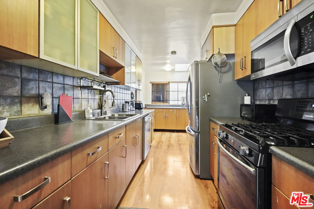2477 Coolidge Avenue Los Angeles, CA 90064 - Photo 22 of 30 a kitchen with stainless steel appliances granite countertop a sink a stove and a wooden floors