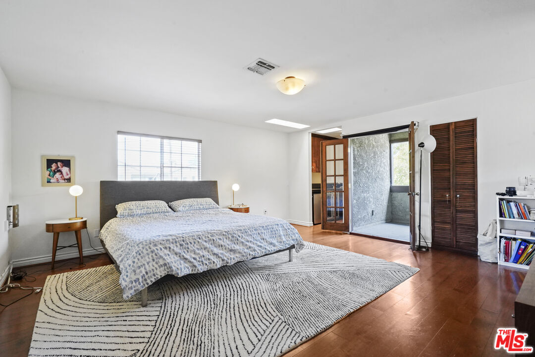 2477 Coolidge Avenue Los Angeles, CA 90064 - Photo 24 of 30 a bedroom with a large bed and a wooden floor