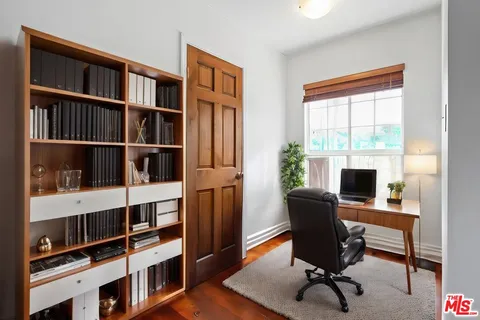 a view of a workspace with furniture and a window