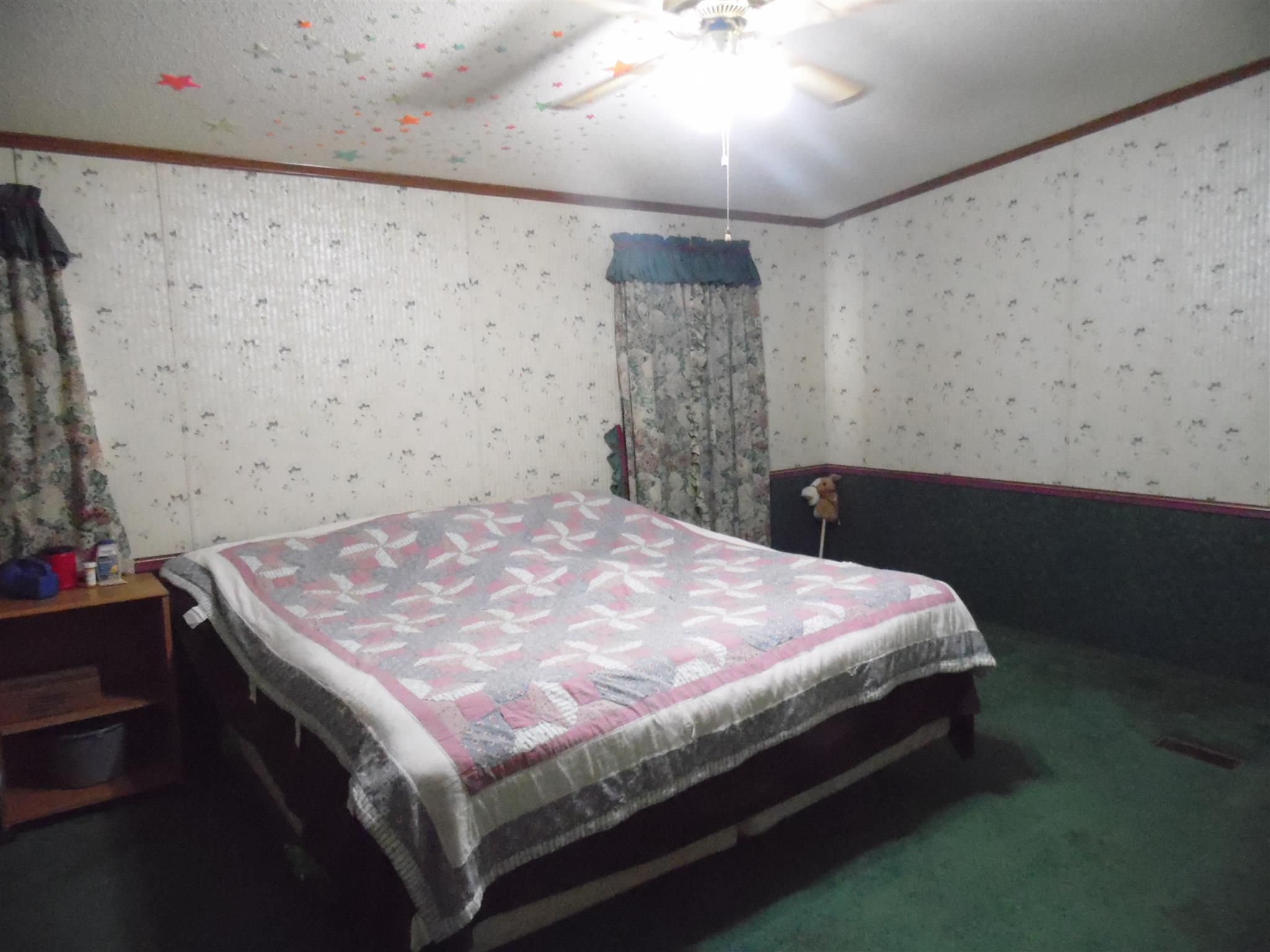 6531 Porters Branch Road Santa Fe, TN 38482 - Photo 15 of 18 a bed sitting in a bedroom next to a lamp