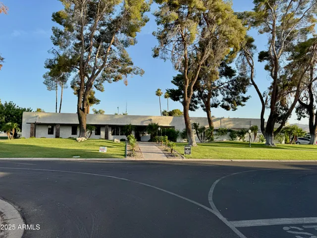a view of a house with a big yard and large trees