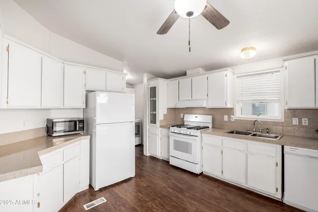 a kitchen with cabinets stainless steel appliances a sink and wooden floor