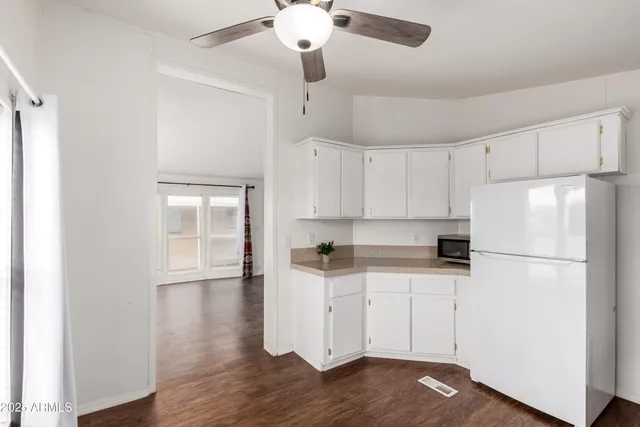 a kitchen with granite countertop a refrigerator a sink and dishwasher