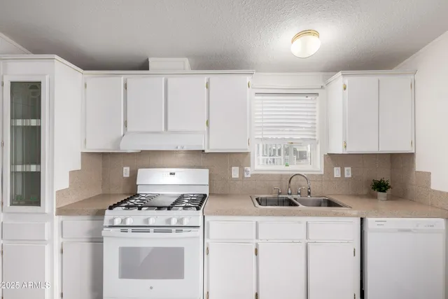 a kitchen with cabinets appliances a sink and a counter top space