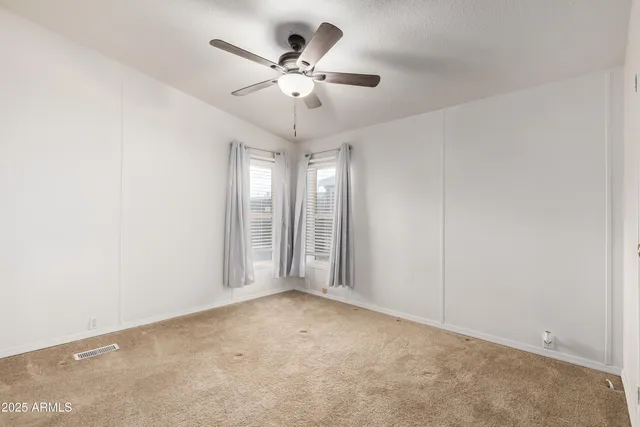 an empty room with chandelier fan