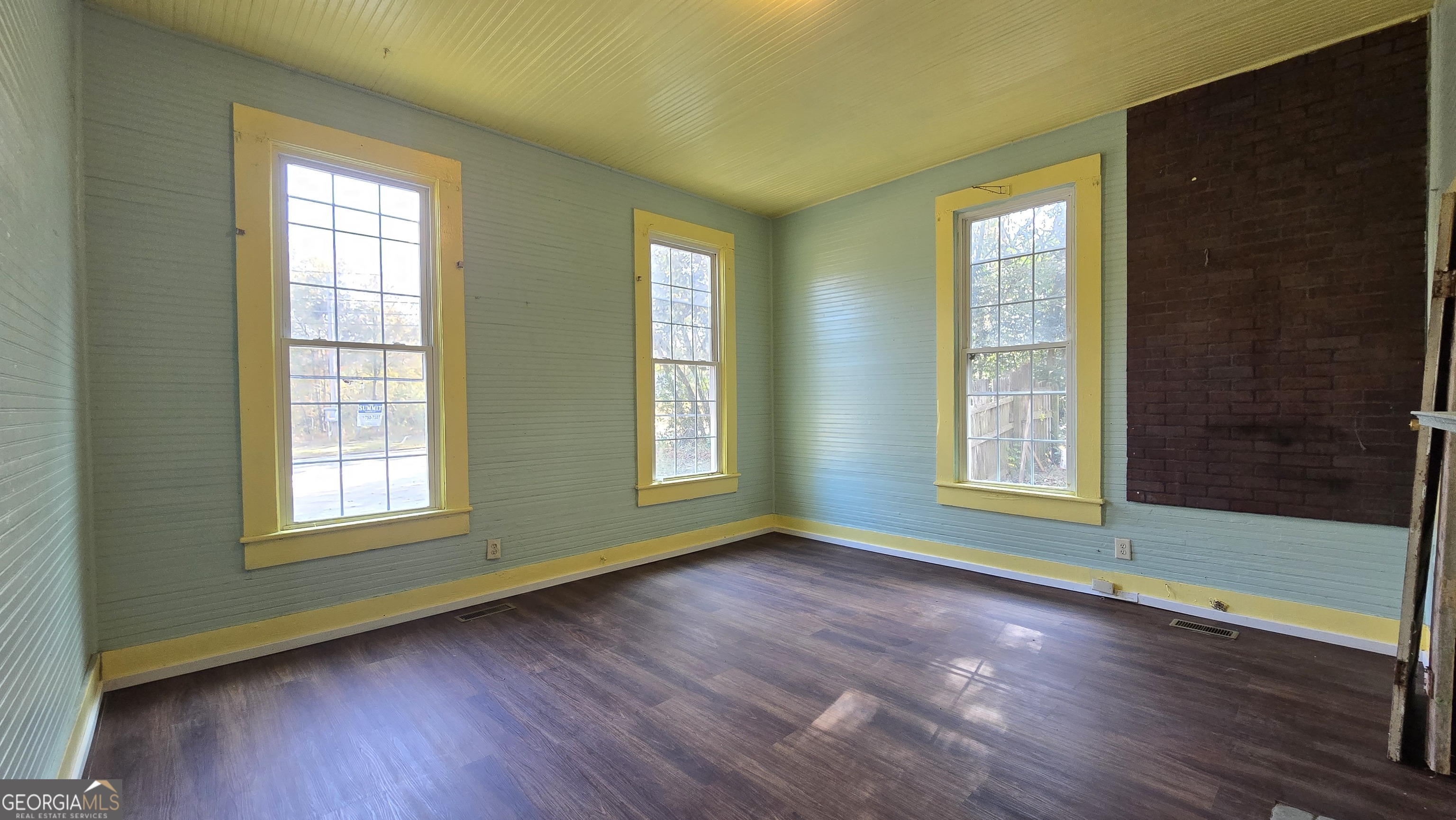 509 Anderson Avenue Fort Valley, GA 31030 - Photo 12 of 22 a view of an empty room with wooden floor and a window