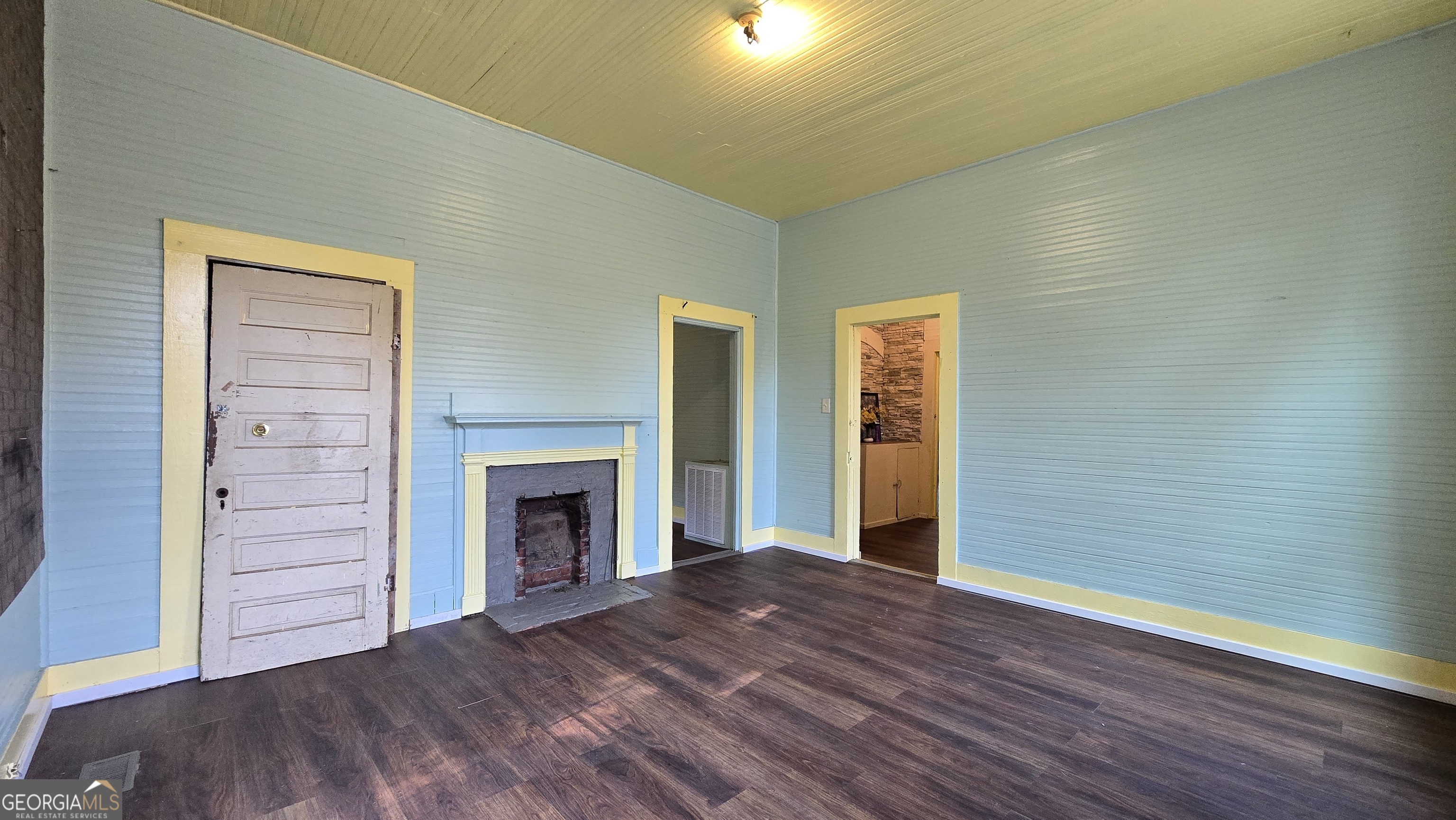 509 Anderson Avenue Fort Valley, GA 31030 - Photo 13 of 22 a view of an empty room with wooden floor fireplace and a window