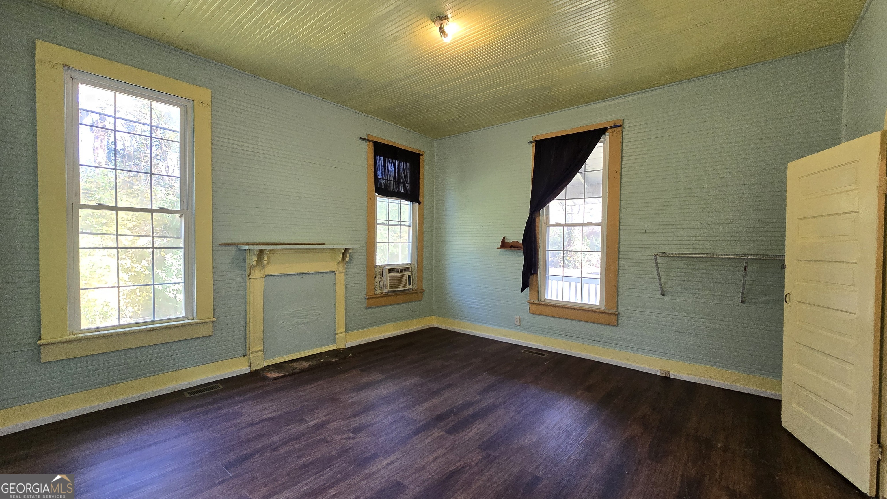 509 Anderson Avenue Fort Valley, GA 31030 - Photo 7 of 22 a view of an empty room with wooden floor and a window