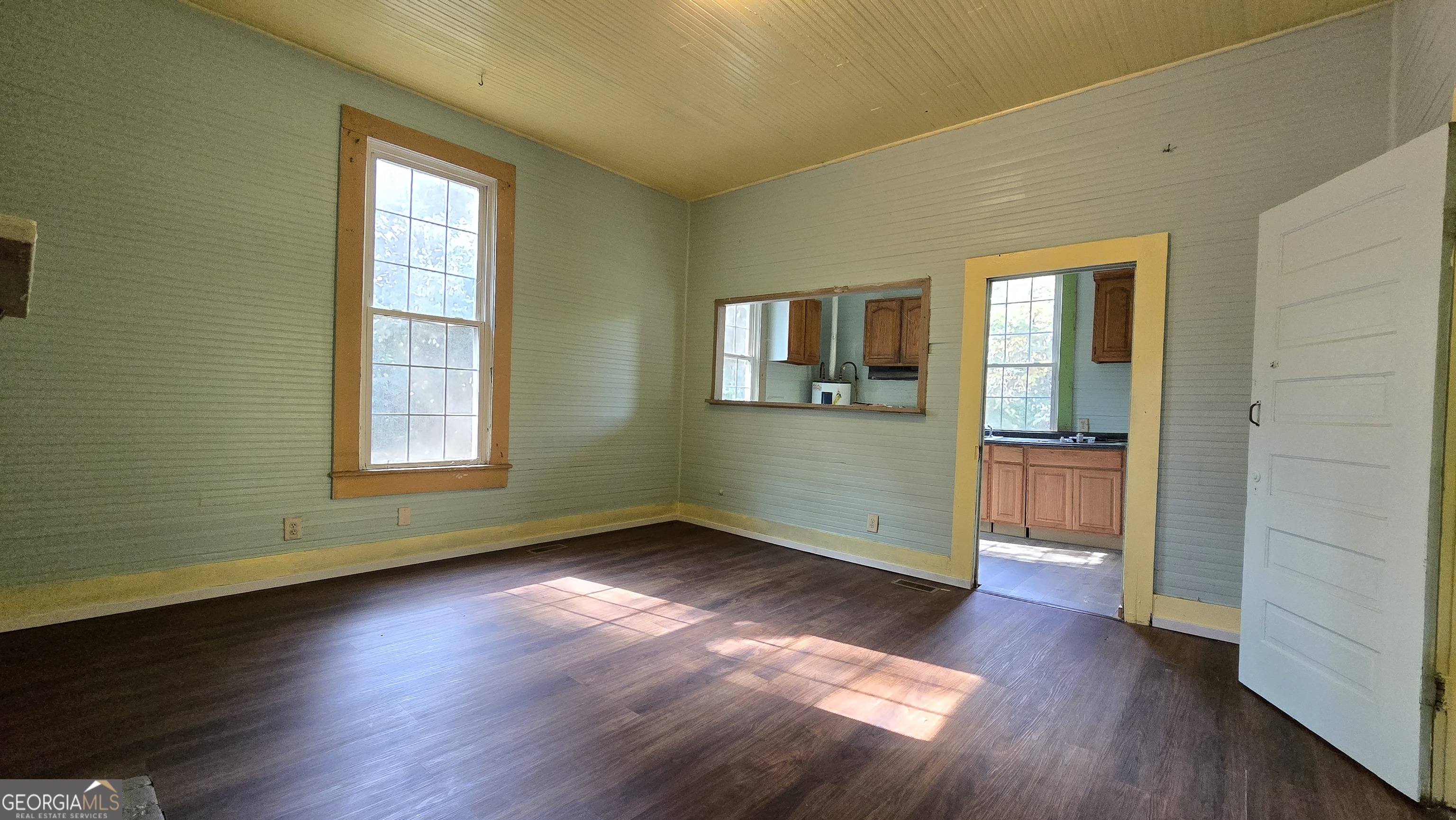 509 Anderson Avenue Fort Valley, GA 31030 - Photo 9 of 22 an empty room with wooden floor and windows