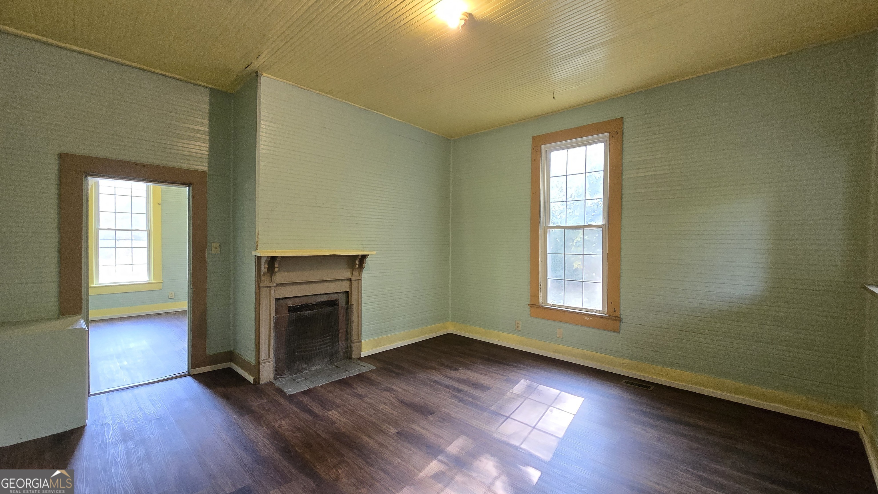509 Anderson Avenue Fort Valley, GA 31030 - Photo 10 of 22 a view of an empty room with wooden floor and a window