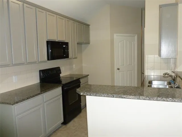 a kitchen with a sink and a stove top oven
