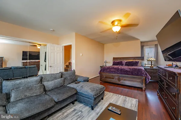a living room with furniture a flat screen tv and a chandelier