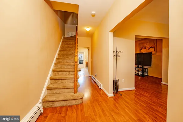 a view of a hallway with wooden floor and staircase
