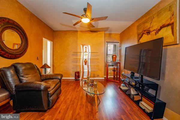 a living room with furniture a flat screen tv and floor to ceiling window