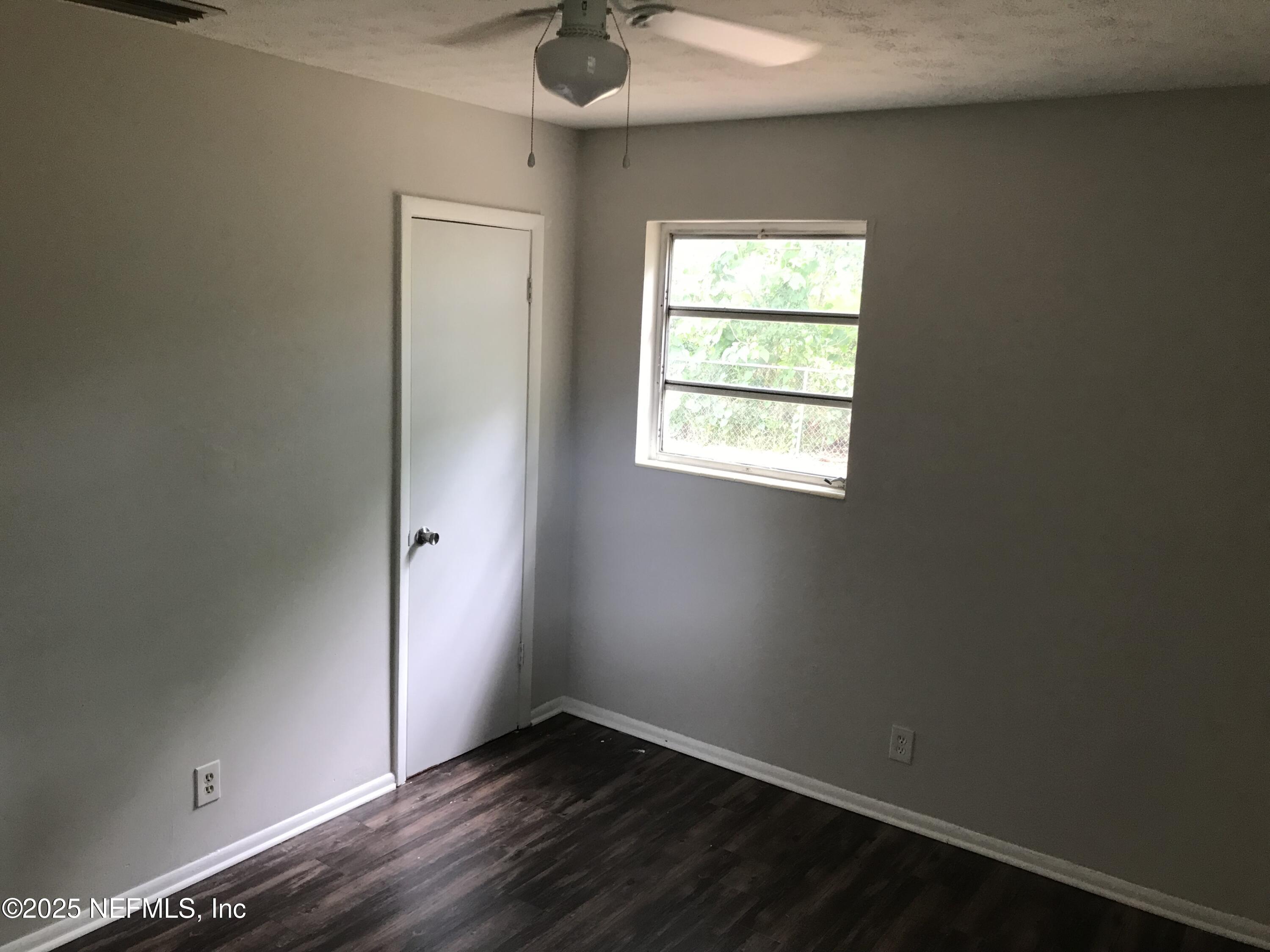 7419 Sandhurst Road South Jacksonville, FL 32277 - Photo 11 of 16 an empty room with wooden floor and windows