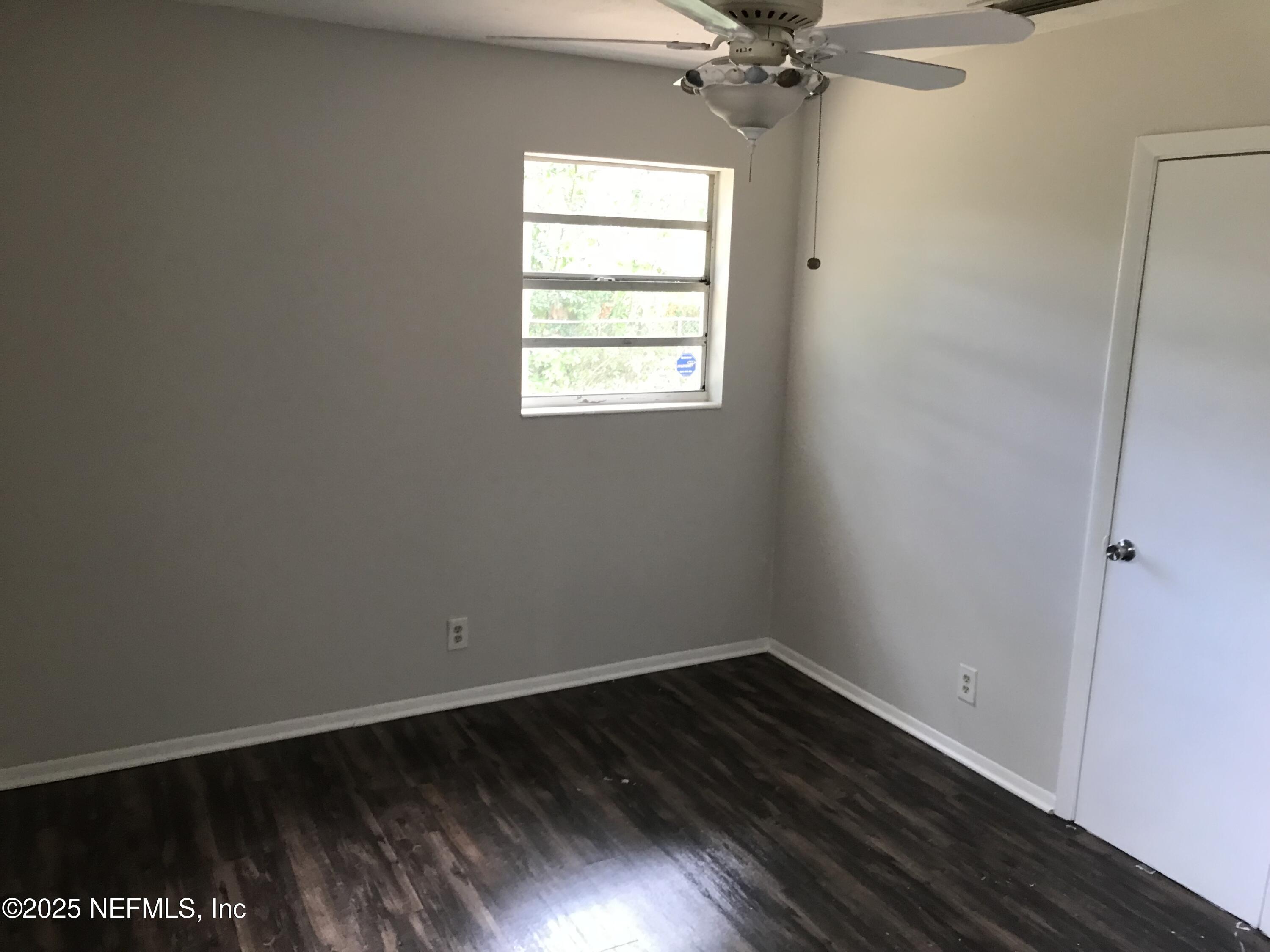 7419 Sandhurst Road South Jacksonville, FL 32277 - Photo 14 of 16 an empty room with wooden floor fan and windows
