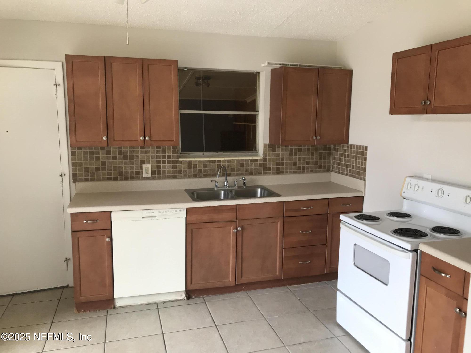 7419 Sandhurst Road South Jacksonville, FL 32277 - Photo 5 of 16 a kitchen with stainless steel appliances granite countertop a sink stove and cabinets