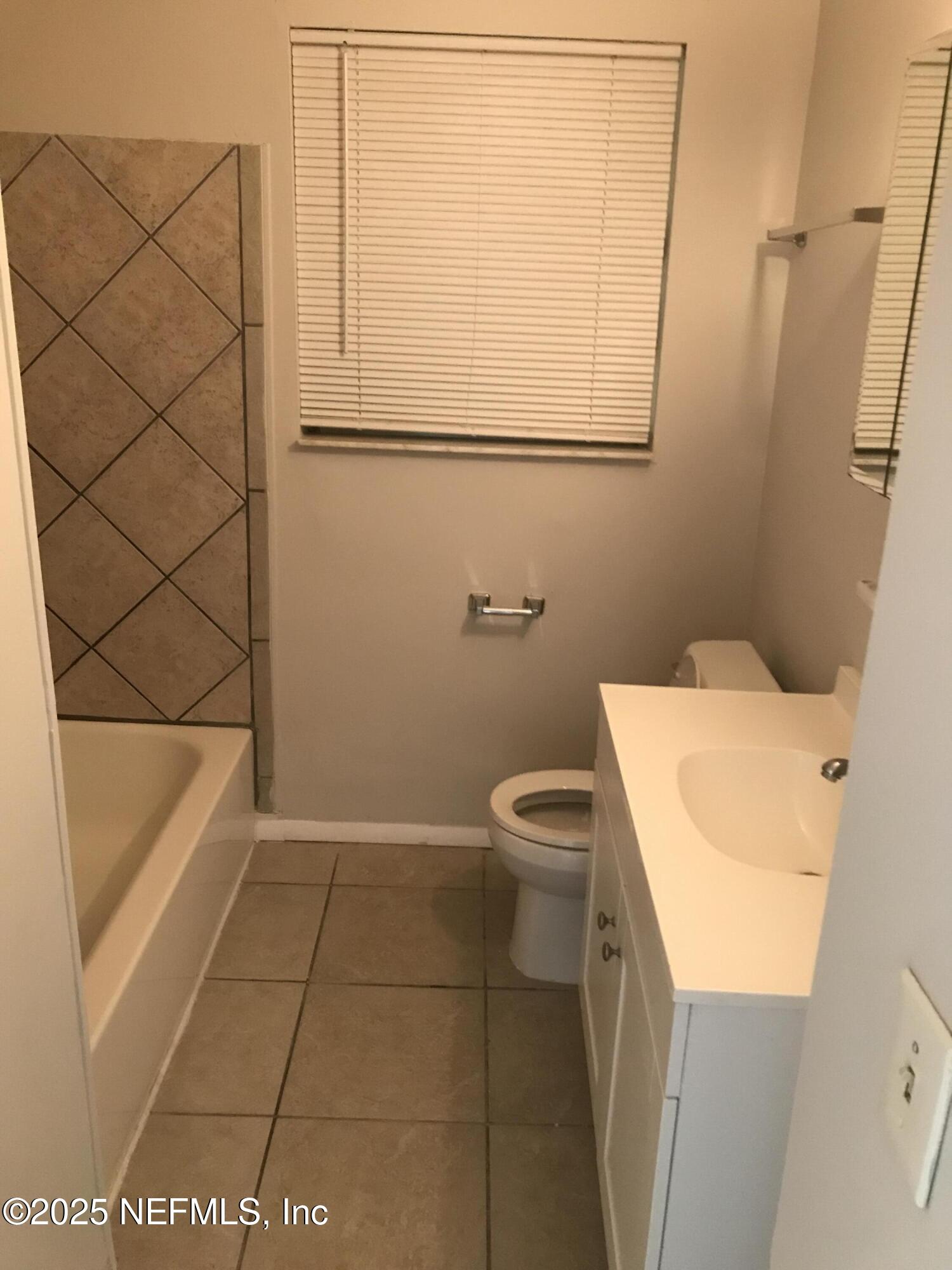 7419 Sandhurst Road South Jacksonville, FL 32277 - Photo 7 of 16 a bathroom with a toilet and a bath tub