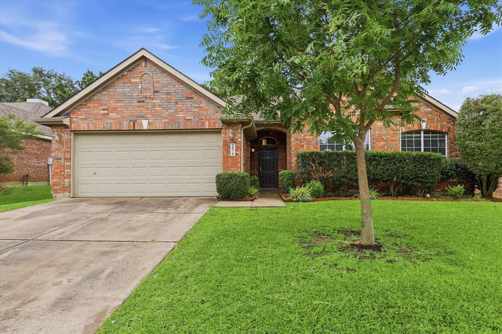 2616 Hollow Ridge Drive Denton, TX 76210 - Photo 2 of 31 Brick exterior featuring a two-car garage, mature front yard landscaping, arched entry, and decorative arched windows