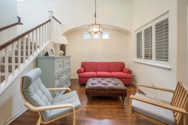 a living room with furniture a dining table and a chandelier