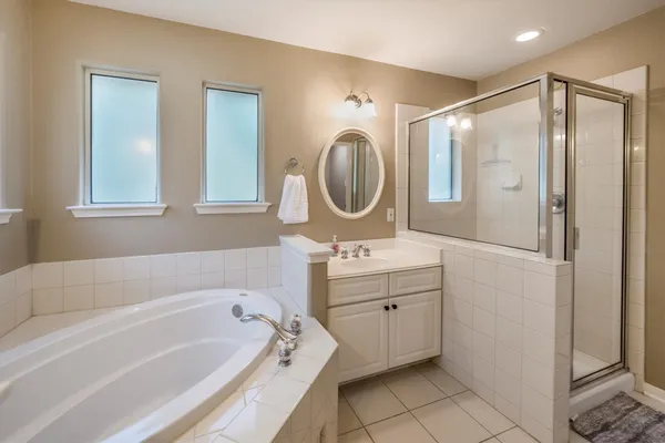 a bathroom with a tub sink and mirror