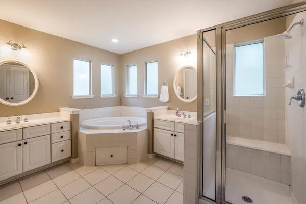 a spacious bathroom with a double vanity sink mirror and shower
