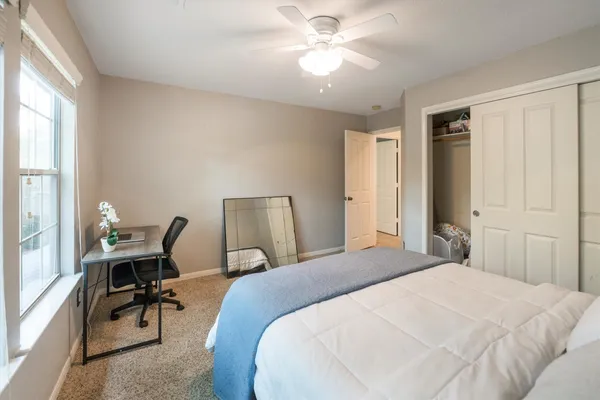 a bedroom with a bed a desk and chair