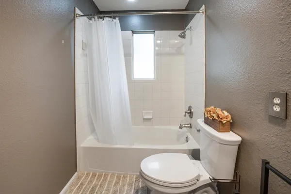 a white toilet sitting next to a bath tub