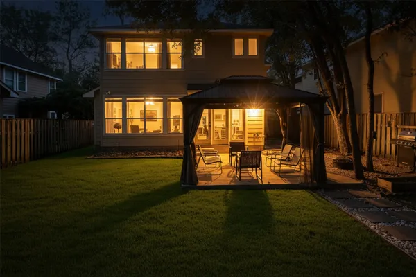 a view of a house with backyard and sitting area