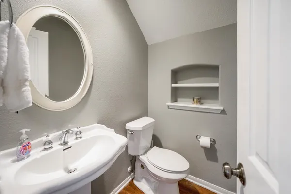 a bathroom with a sink mirror and toilet