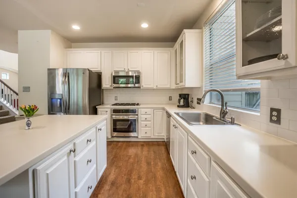 a kitchen with stainless steel appliances sink stove refrigerator and cabinets