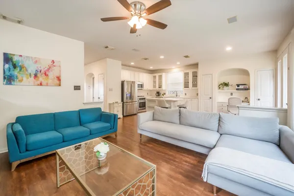 a living room with furniture and a view of kitchen