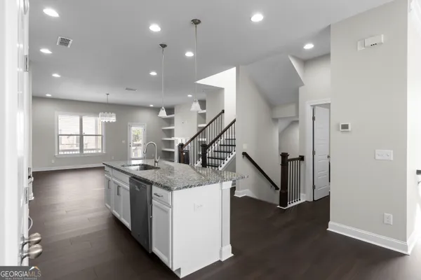 a kitchen with stainless steel appliances granite countertop a sink and a large window