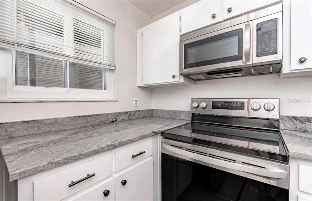 39132 County Road 54, Unit 2180 Zephyrhills, FL 33542 - Photo 2 of 19 a kitchen with a stove microwave and sink