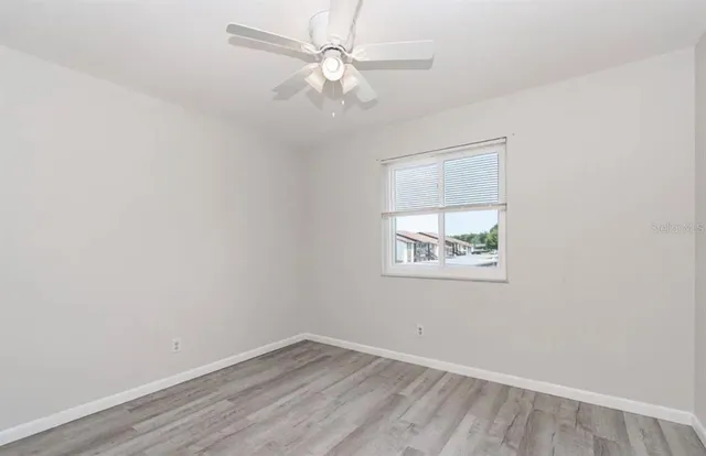an empty room with a window and a fan
