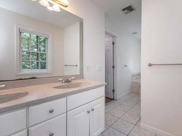 a spacious bathroom with a sink and a mirror
