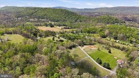 an aerial view of residential houses with outdoor space and trees