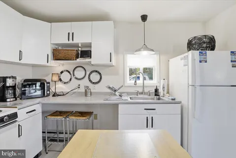 a kitchen with stainless steel appliances a sink a refrigerator a stove a microwave and cabinets