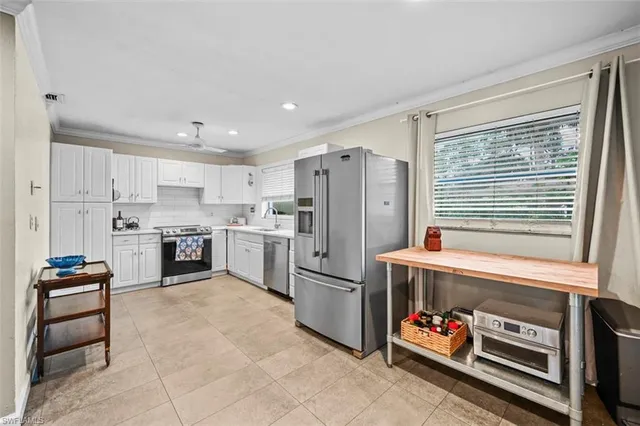 a kitchen with granite countertop a refrigerator and a stove top oven