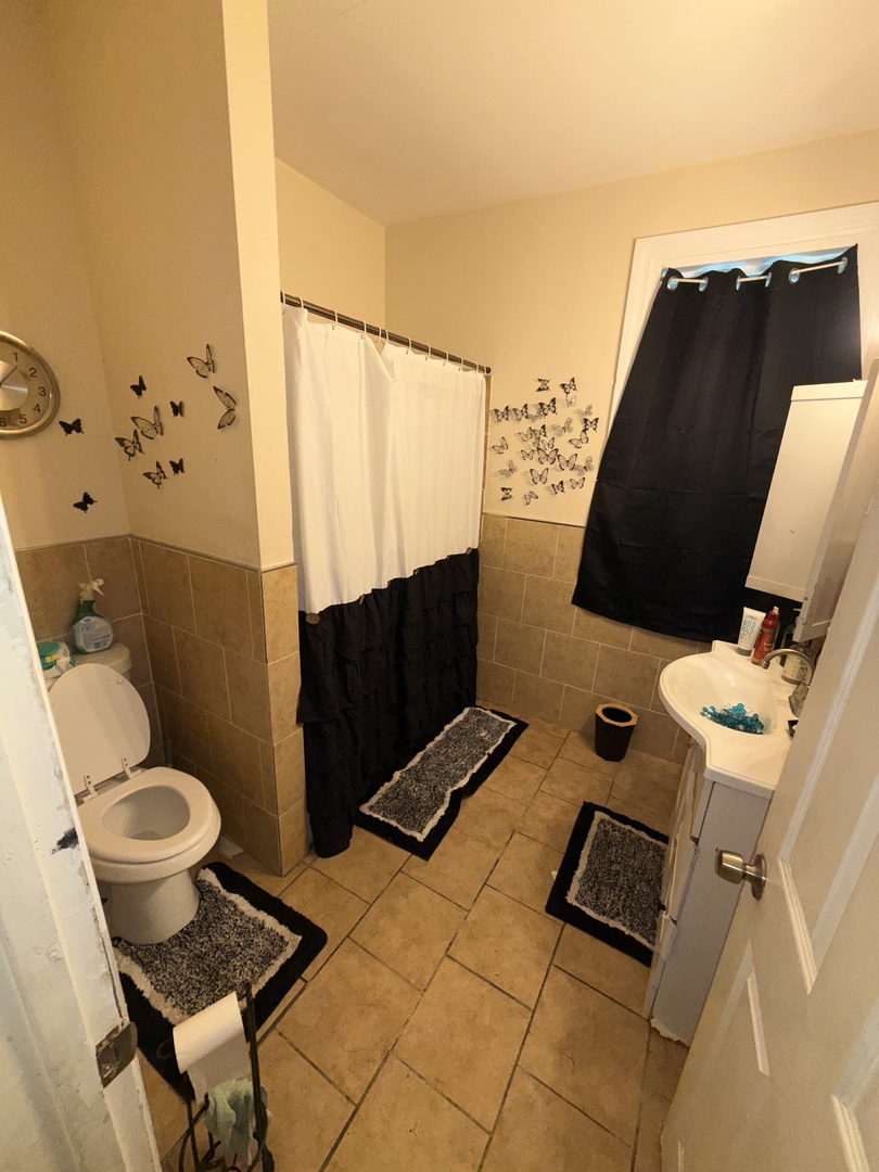 7916 South Normal Avenue Chicago, IL 60620 - Photo 5 of 6 a bathroom with a toilet and a mirror