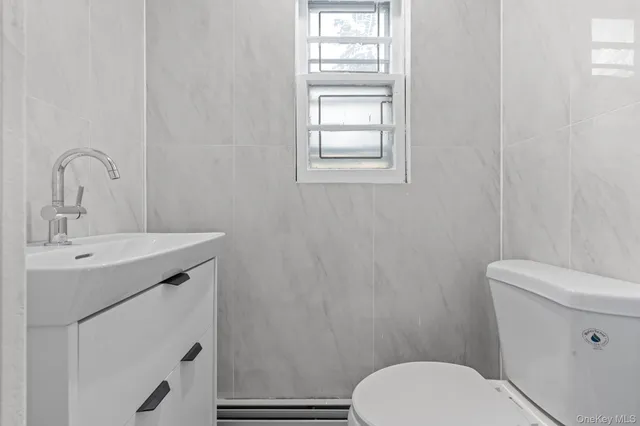 a bathroom with a toilet sink vanity and mirror