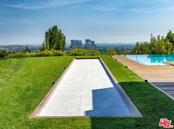 a room with lots of wooden furniture and a glass door shower