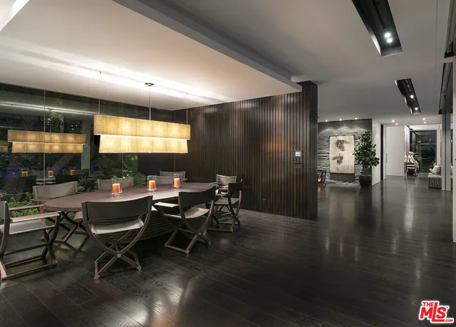 a bedroom with a bed a dresser with wooden floor