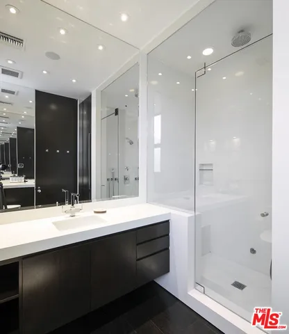a large white bathroom with a large tub sink shower and mirror