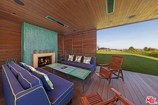 a outdoor sitting area with furniture and a fireplace