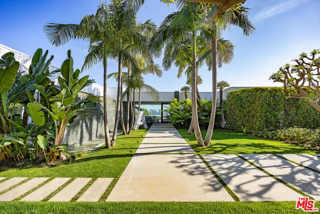 a front view of a house with a yard and potted plants