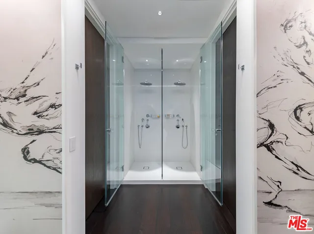 a room with lots of white furniture and wooden floor