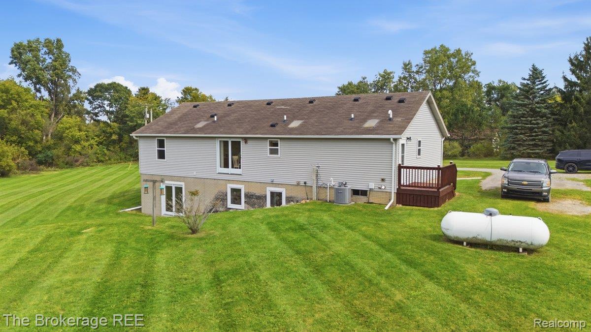 2422 South Henderson Road Davison, MI 48423 - Photo 45 of 53 Sloped lot with extensive lawn, light gray siding, and a brown deck